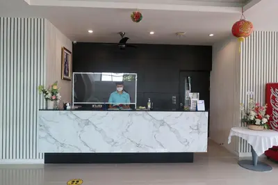 a man standing behind a counter in a kitchen at S4 Nai Yang Beach - Near Phuket Airport in Nai Yang Beach