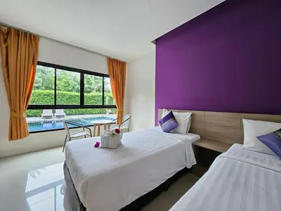 a bedroom with two beds and a purple wall at S4 Nai Yang Beach - Near Phuket Airport in Nai Yang Beach