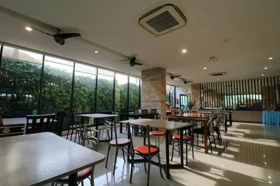 a restaurant with tables and chairs and large windows at S4 Nai Yang Beach - Near Phuket Airport in Nai Yang Beach