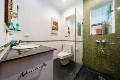 a bathroom with a toilet and a sink and a shower at Kamala Beach Estate Resort - SHA Extra Plus in Kamala Beach