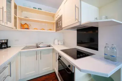 a kitchen with white cabinets and a sink at Kamala Beach Estate Resort - SHA Extra Plus in Kamala Beach