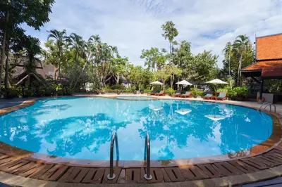 a large pool at a resort with chairs and umbrellas at Kamala Beach Estate Resort - SHA Extra Plus in Kamala Beach