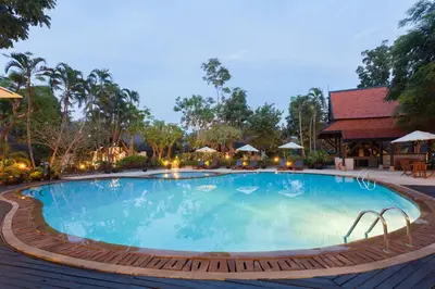 a large swimming pool at a resort at night at Kamala Beach Estate Resort - SHA Extra Plus in Kamala Beach