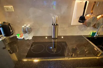 a kitchen counter with a sink with chopsticks on it at Platinum Hotel and Apartments in Patong Beach