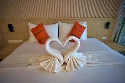two swans making a heart shape on a bed at Platinum Hotel and Apartments in Patong Beach