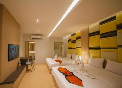 a hotel room with two beds and a television at Platinum Hotel and Apartments in Patong Beach