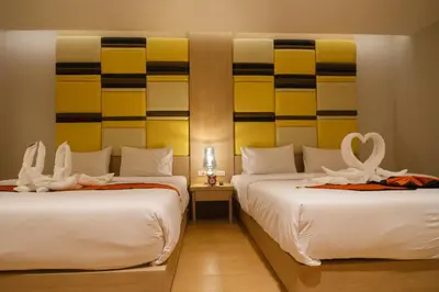 two beds in a hotel room with towels on them at Platinum Hotel and Apartments in Patong Beach