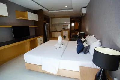 a bedroom with a large white bed with blue pillows at Platinum Hotel and Apartments in Patong Beach
