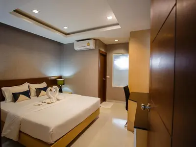 a bedroom with a bed with a towel on it at Platinum Hotel and Apartments in Patong Beach