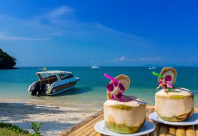 a beach with two cakes with sandals and a boat at Elixir Resort Koh Yao Yai - SHA Plus in Ko Yao Yai