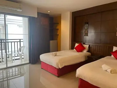 a hotel room with two beds and a balcony at Thai Siam in Patong Beach