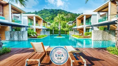 a resort with a swimming pool with two chairs at Wyndham Sea Pearl Resort, Phuket in Patong Beach