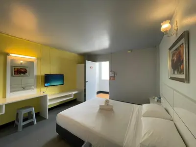 a bedroom with a white bed and a tv at Summer Hotel in Phuket Town
