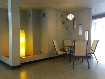 a dining room with a table and chairs and a light at Summer Hotel in Phuket Town