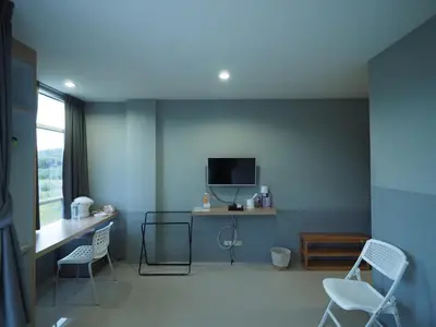 a room with two chairs and a desk and a tv at Sleepwell@naiyang in Nai Yang Beach