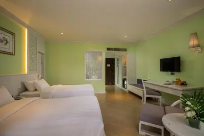 a hotel room with two beds and a desk at Aonang Villa Resort l Lifestyle Beachfront Resort in Ao Nang Beach