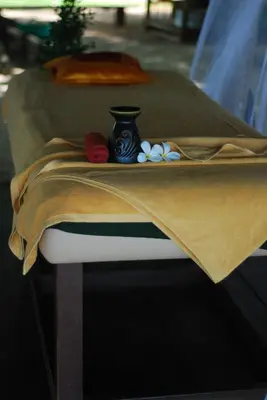 a table with a bed with a vase on it at KhaoTong Villa at Melina's in Tha Lane Bay