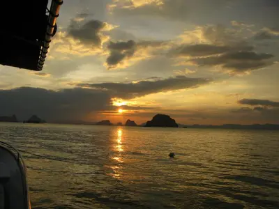 a sunset from a boat in the water at KhaoTong Villa at Melina's in Tha Lane Bay