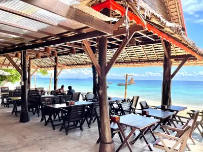 a restaurant on the beach with tables and chairs at Phi Phi Relax Beach Resort in Phi Phi Don