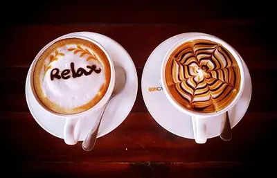 two cups of coffee on plates on a table at Phi Phi Relax Beach Resort in Phi Phi Don