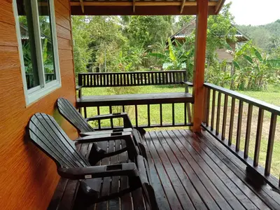 two chairs on the porch of a house at Cha Bungalow in Ko Yao Noi