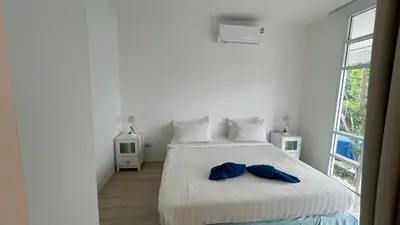 a bedroom with a bed with two blue towels on it at PP Blue Sky Resort-SHA Plus in Phi Phi Don