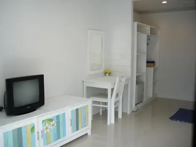 a living room with a tv and a table and a desk at PP Blue Sky Resort-SHA Plus in Phi Phi Don