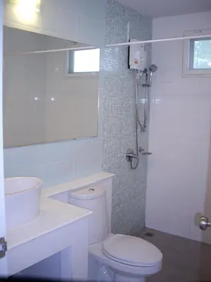 a white bathroom with a toilet and a sink at PP Blue Sky Resort-SHA Plus in Phi Phi Don