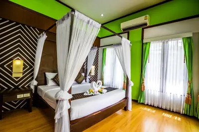 a bedroom with two beds and green walls at Phi Phi Andaman Beach Resort in Phi Phi Don