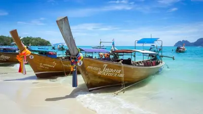 two boats on the shore of a beach at Phi Phi Andaman Beach Resort in Phi Phi Don
