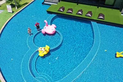 two people are playing in a swimming pool with toys at Phi Phi Andaman Legacy Resort in Phi Phi Don