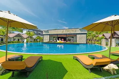 a large swimming pool with chairs and umbrellas at Phi Phi Andaman Legacy Resort in Phi Phi Don