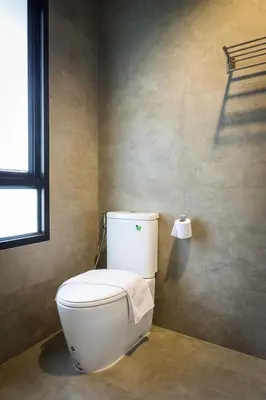 a white toilet in a bathroom with a window at Villa Raeya in Ao Nang Beach