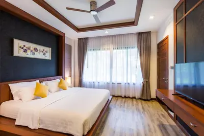 a bedroom with a large bed and a flat screen tv at Villa Raeya in Ao Nang Beach
