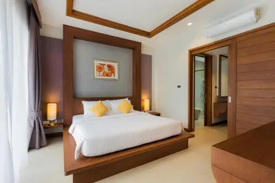 a bedroom with a large bed with white sheets and yellow pillows at Villa Palavee (B3) in Ao Nang Beach