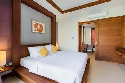 a bedroom with a white bed with a wooden headboard at Villa Palavee (B3) in Ao Nang Beach