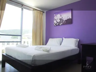 a bedroom with a bed with a purple wall at Ivory Phi Phi Island in Phi Phi Don