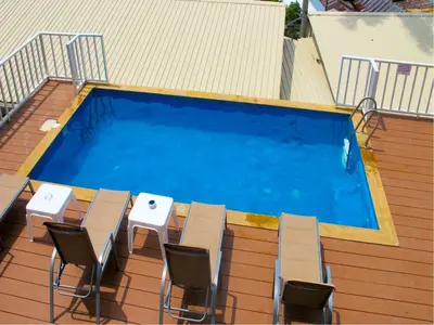a swimming pool with a table and chairs next to it at Uphill Cottage in Phi Phi Don