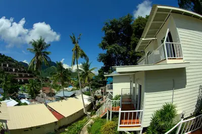 a house with a wrap around porch and a balcony at Uphill Cottage in Phi Phi Don