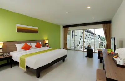 a bedroom with a large bed and a green wall at Kata Sea Breeze Resort - SHA Plus in Kata Beach