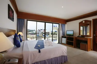 a hotel room with a bed and a large window at Jiraporn Hill Resort in Patong Beach