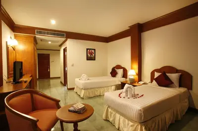a hotel room with two beds and a television at Jiraporn Hill Resort in Patong Beach