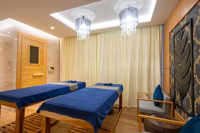 a room with three beds and a chandelier at The Marina Phuket Hotel in Patong Beach