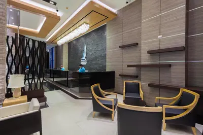a lobby of a hotel with chairs and a bar at The Marina Phuket Hotel in Patong Beach