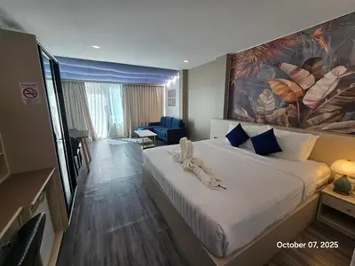 a hotel room with a bed with a large painting on the wall at Modern Living Residence in Patong Beach