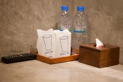 two bottles of water and a box with a remote control at Ritsurin Boutique Hotel - โรงแรมริทสุริน บูติค in Phuket Town
