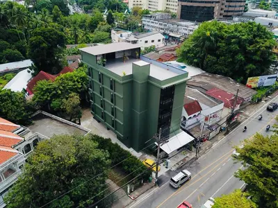 a green building in the middle of a city at Ritsurin Boutique Hotel - โรงแรมริทสุริน บูติค in Phuket Town