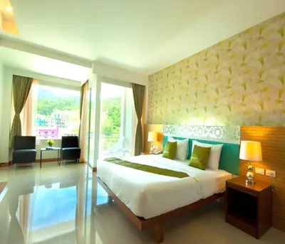 a bedroom with a bed and a large window at PS Hill Resort Phuket Patong - SHA Plus in Patong Beach