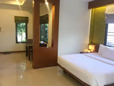 a bedroom with a bed and a mirror and a table at PS Hill Resort Phuket Patong - SHA Plus in Patong Beach