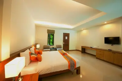 a large bedroom with a bed and a television at PS Hill Resort Phuket Patong - SHA Plus in Patong Beach